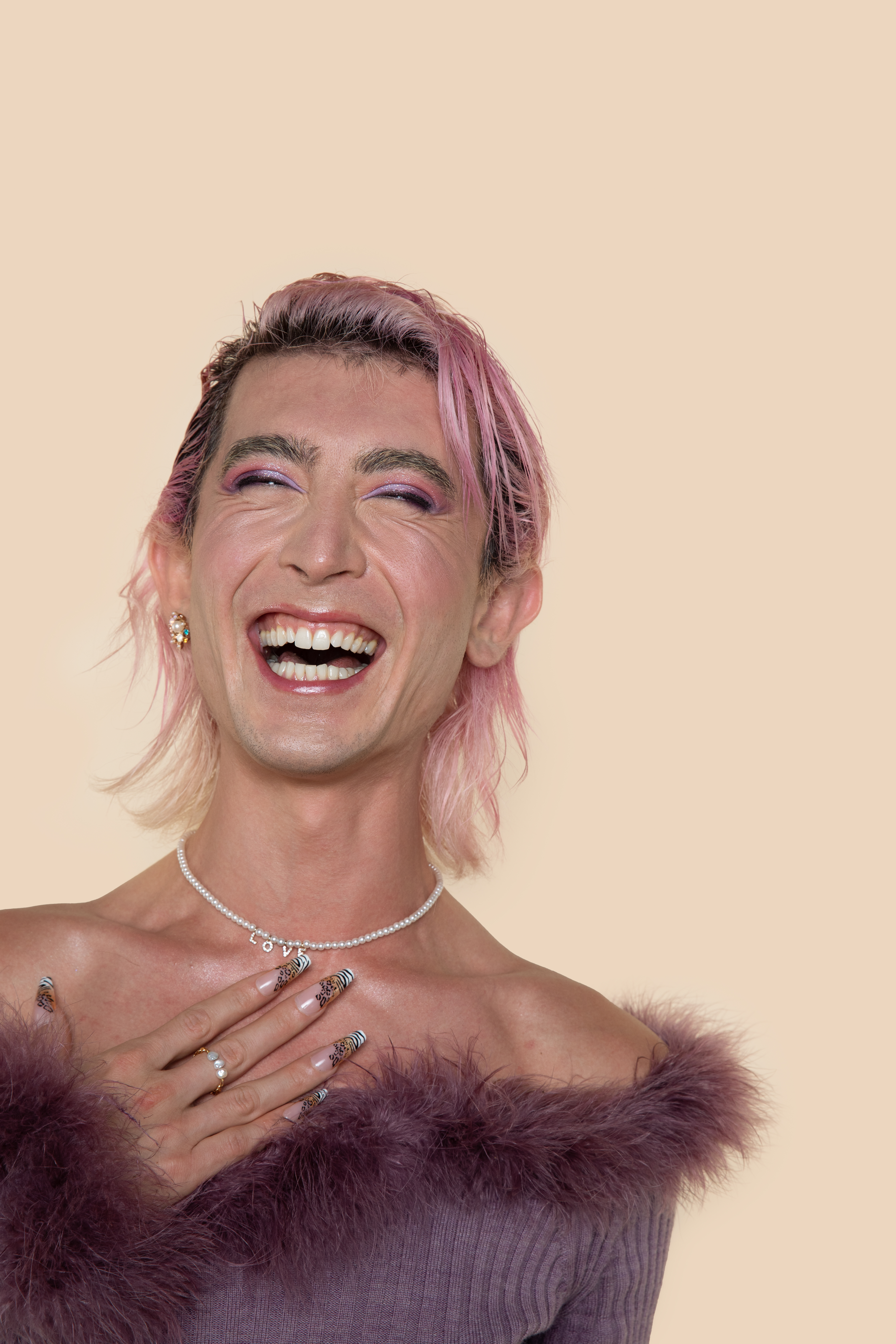 Trans femme person with acrylic nails and love necklace