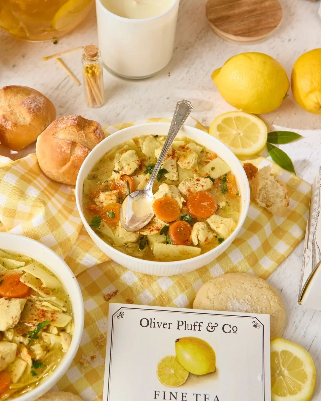 Summer Soup Spread, surrounded by soup, rolls, cookies and lemons on a decorated summer towel.