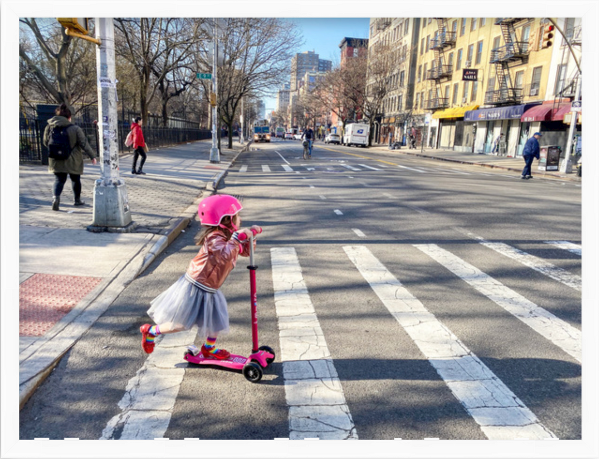 photo of little girl on scooter crossing street in white Irvine slim frame