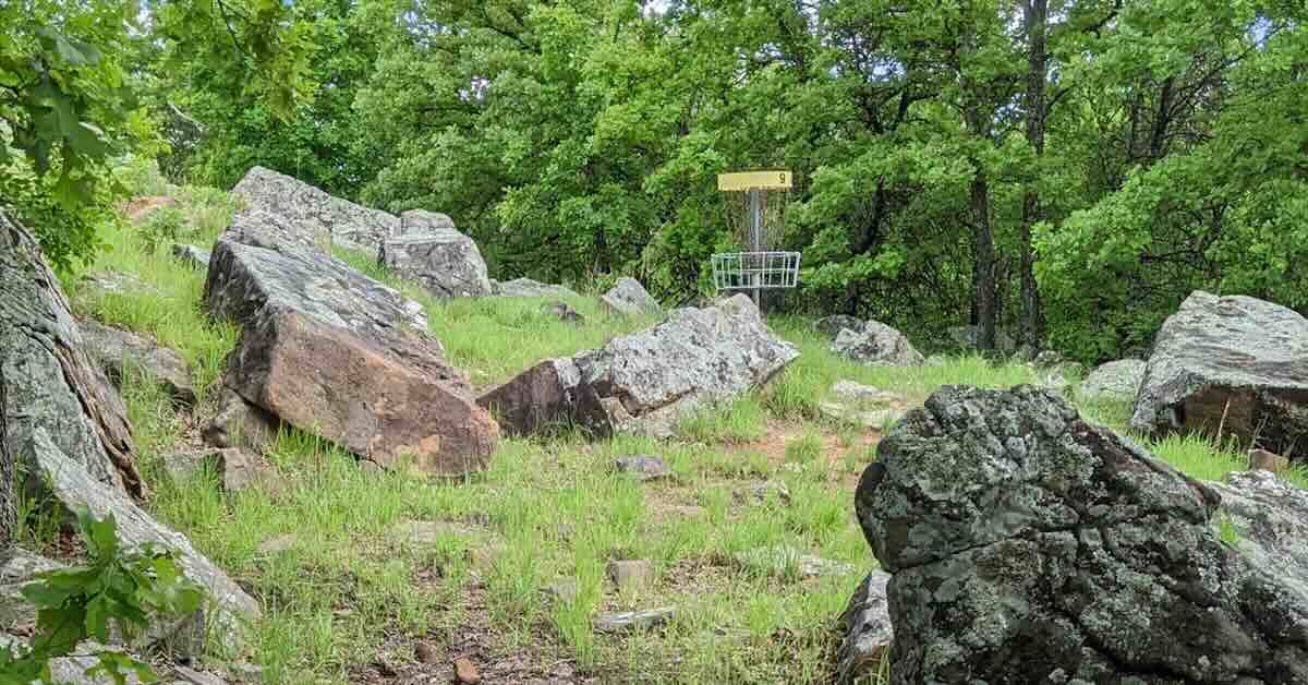 A disc golf basket in a landscape of exposed rocks