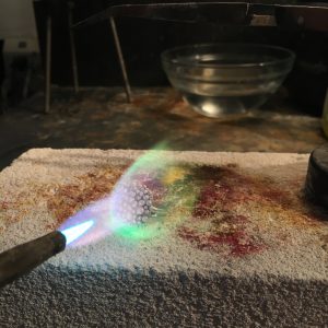 Soldering torch with flame close to piece