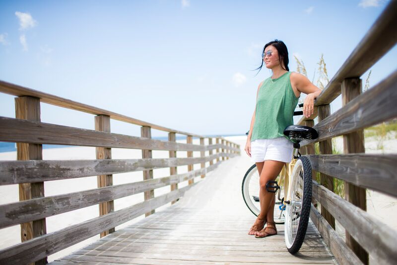 Woman standing on a board walk with a bicycle