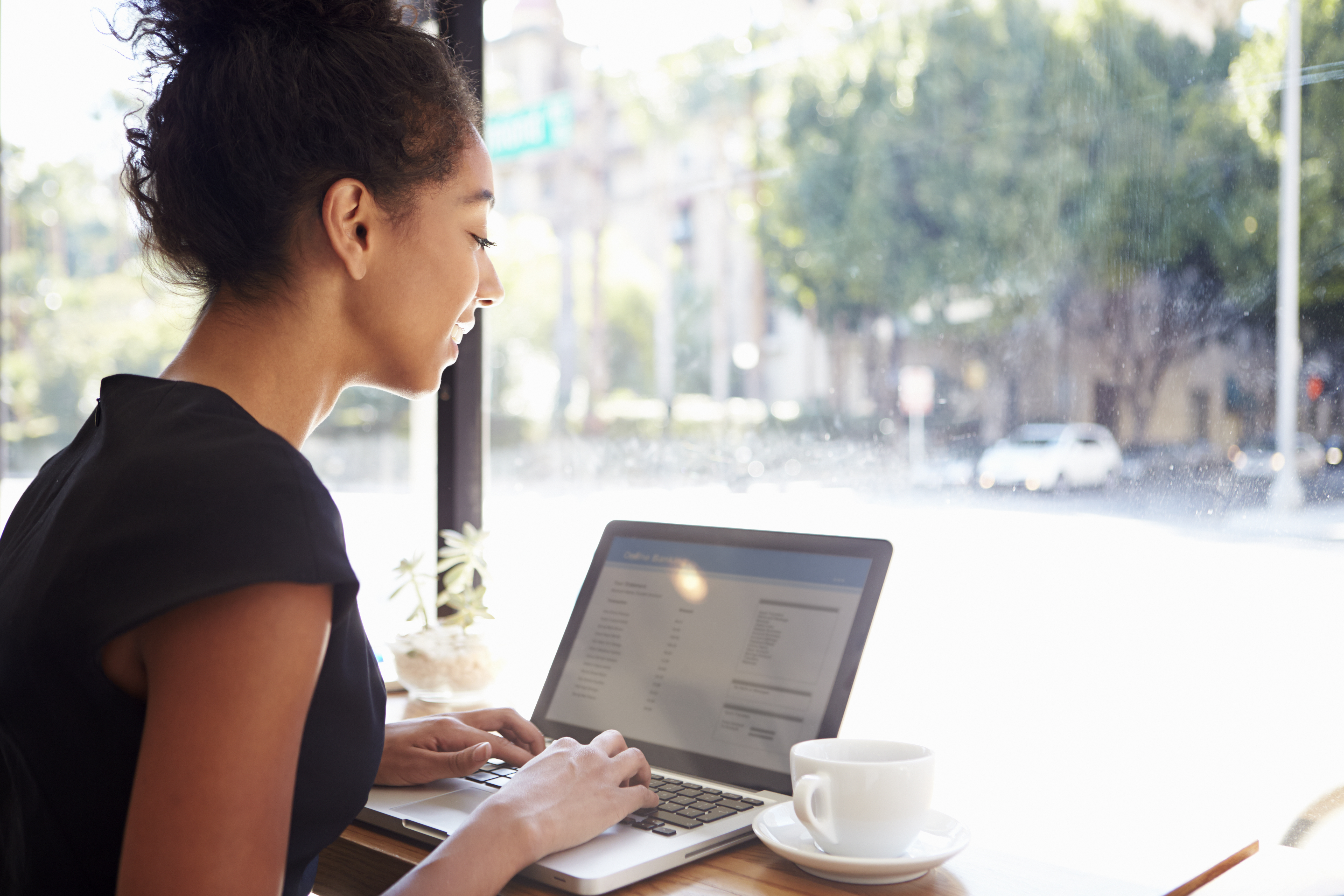 Woman working at a computer in a coffee shop