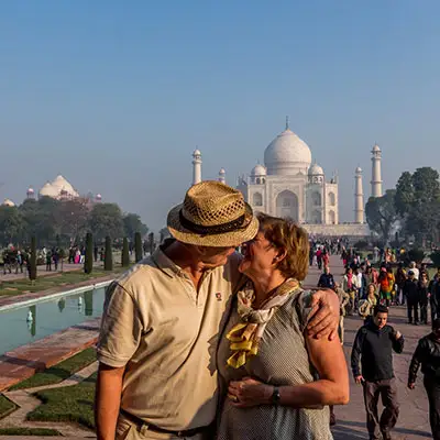 Couple kissing taj mahal.