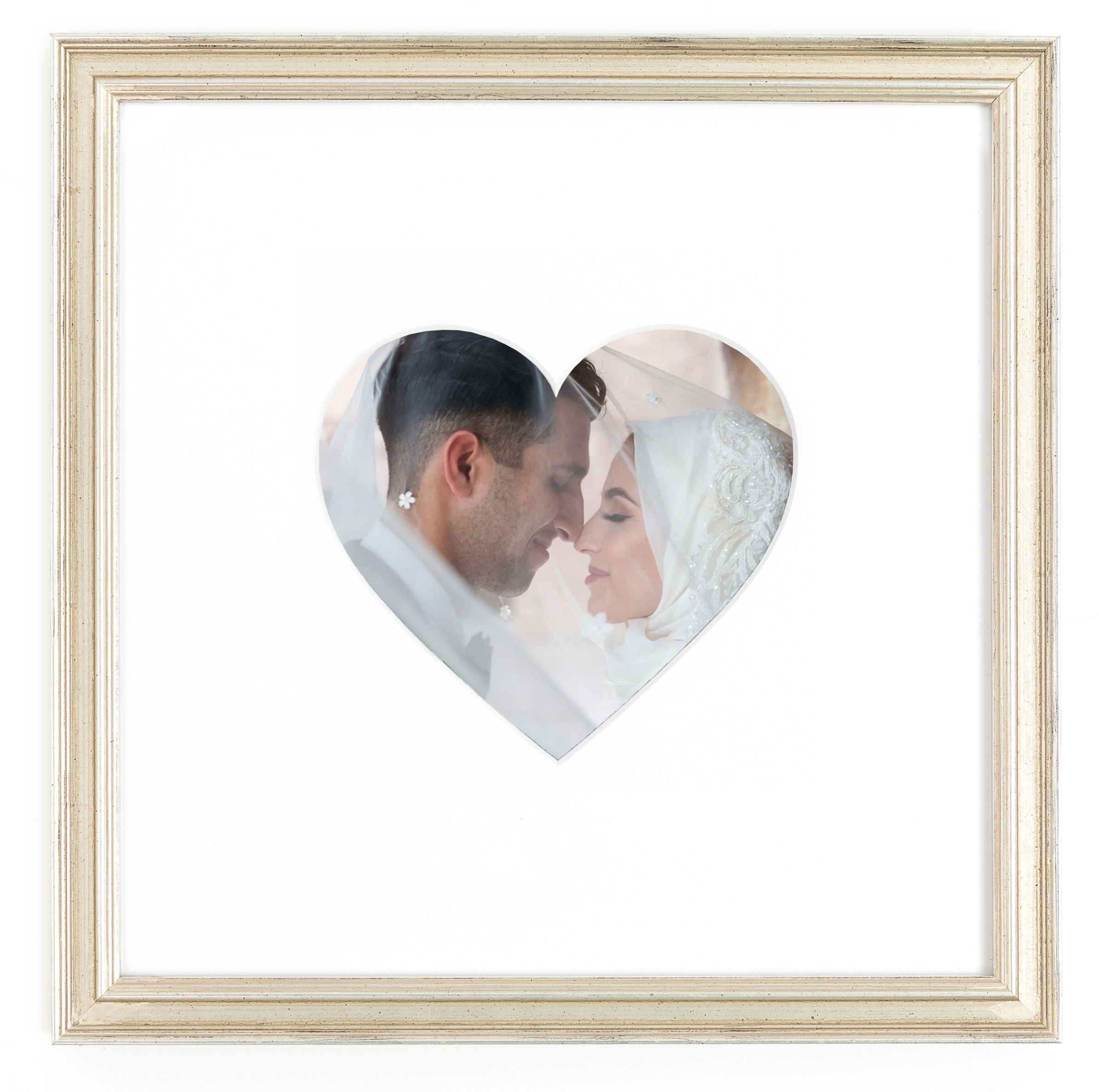 couple on wedding day in heart shaped mat in silver frame