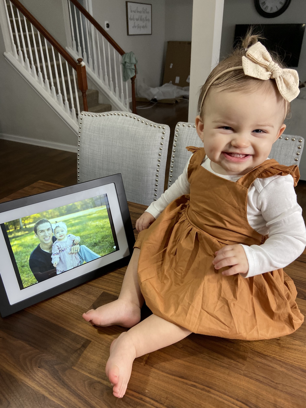 Baby next to digital photo frame with image of her and her dad