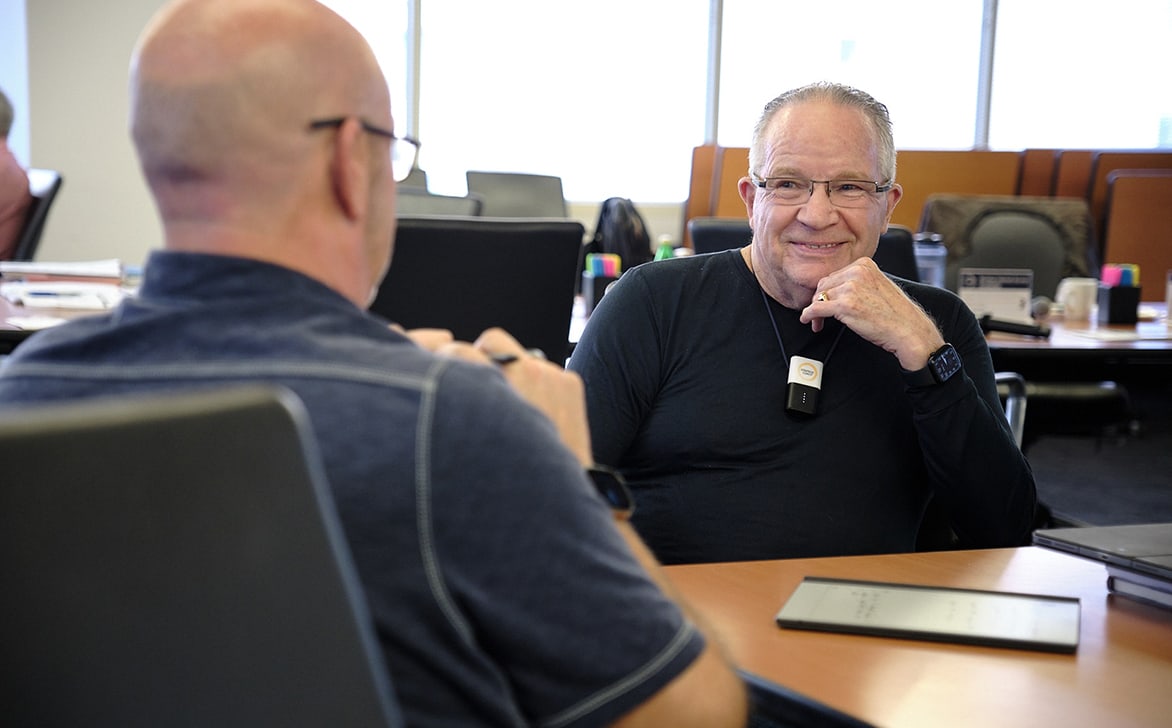 Founder Dan Sullivan sitting at a workshop table with a Strategic Coach Member