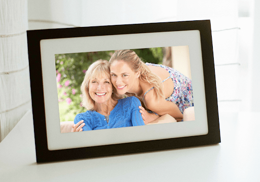 Two women hugging and smiling, displayed on digital photo frame