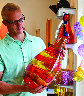 Person holding glass vase at Orbix Hot Glass