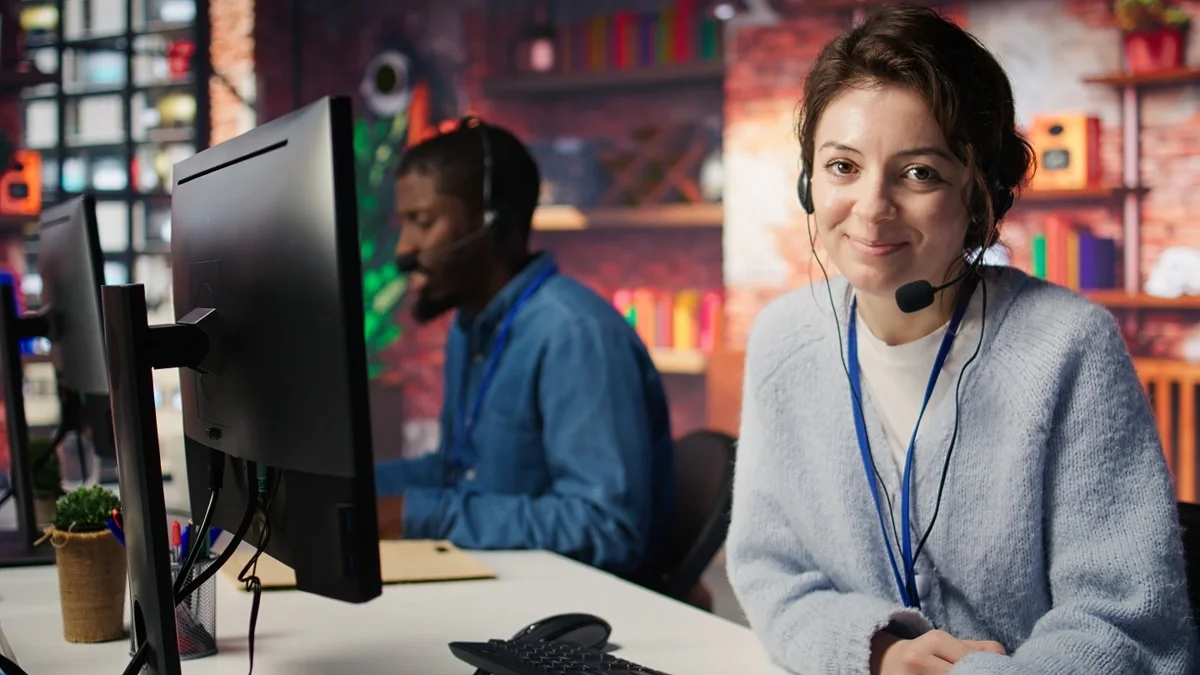 IT helpdesk representative smiling at desk