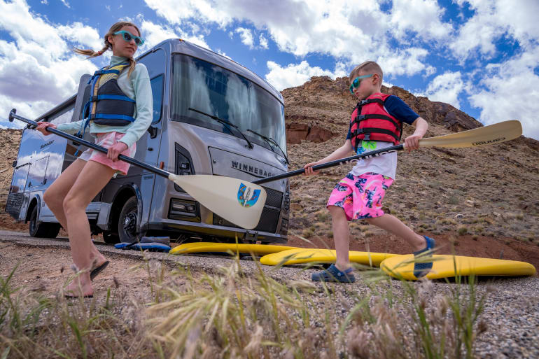 two kids getting kayaks ready outside of Class A