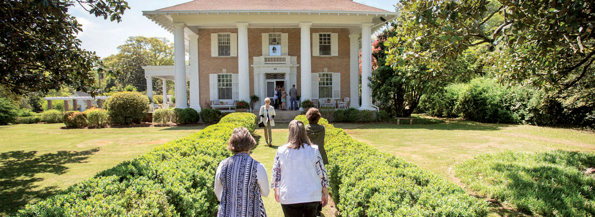 People walking toward a historic home