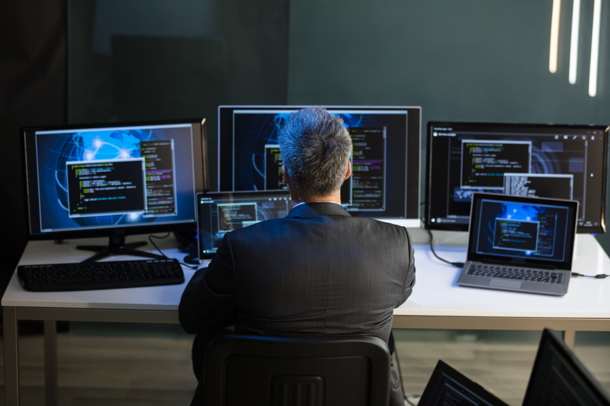 Person looking at four computer monitors