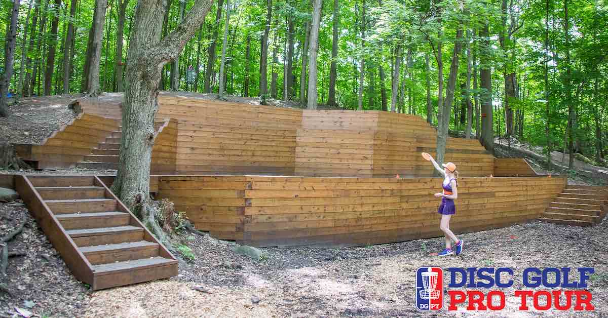 A woman lining up a shot over a large wooden retaining wall that looms above her