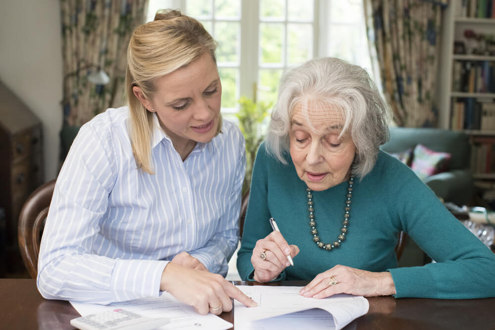 older woman signing papers