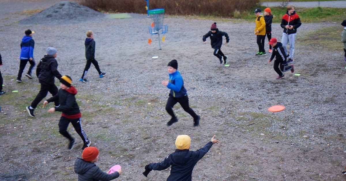 Kids running during a disc golf training session