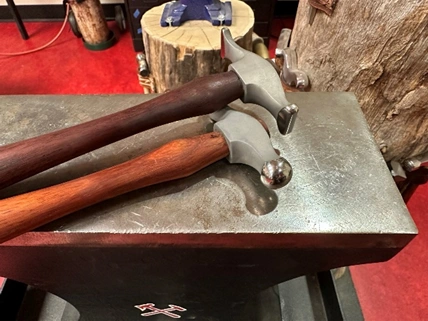A cross pein and ball pein hammer on an anvil