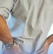 homem com as mãos nas costas, dor na lombar, acompanhamento com ortopedista especializado em quadril