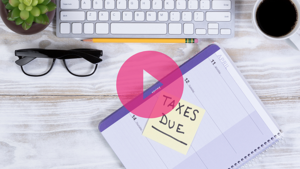 Desk with keyboard, glasses, notebook and a post-it saying Taxes Due