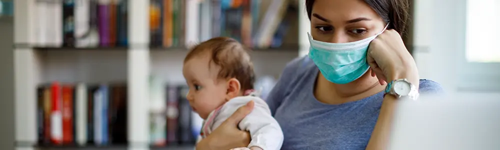 woman with mask working from home with baby