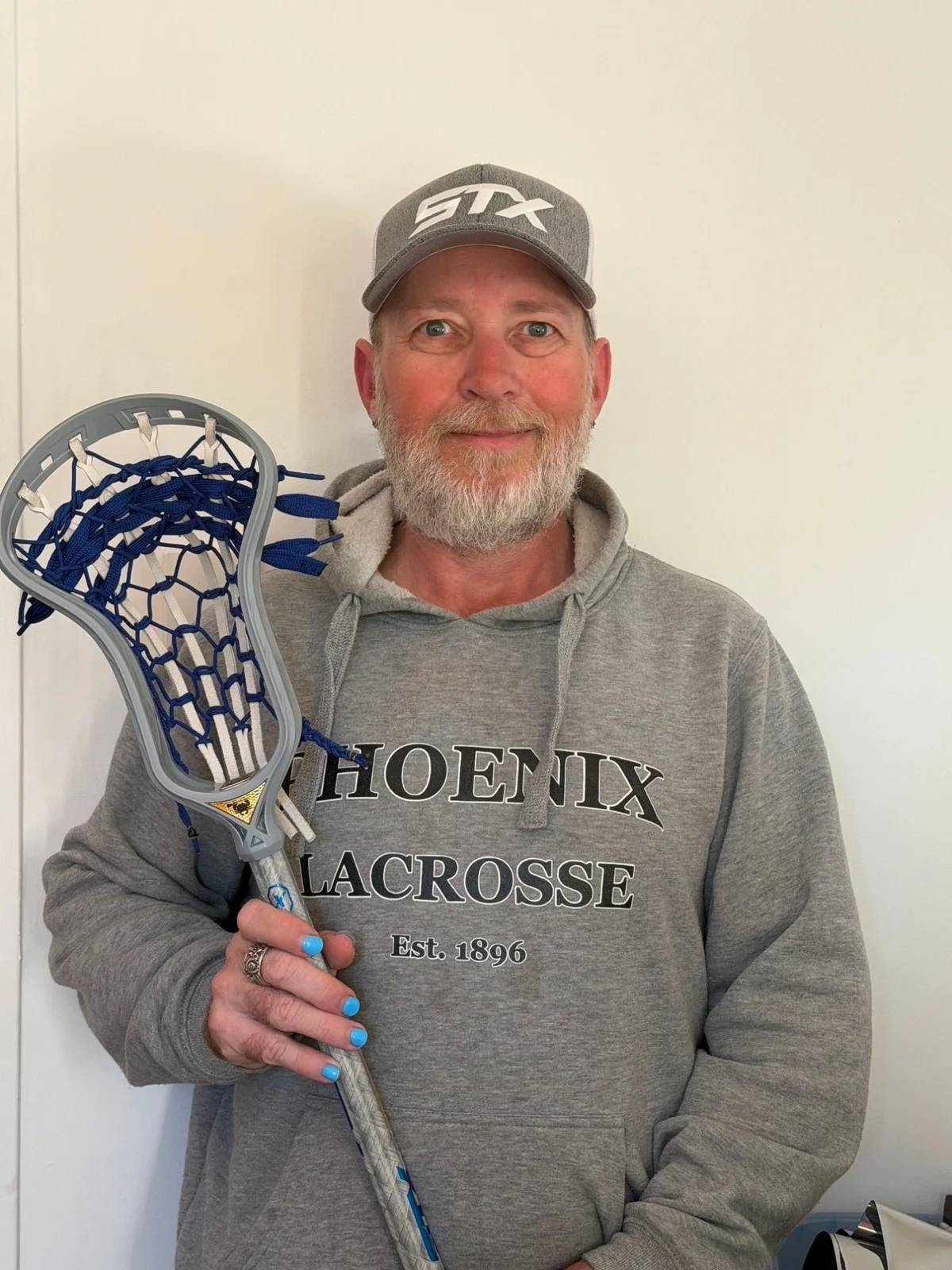 David McKeon holding a lacrosse stick in his Phoenix Lacrosse hoodie