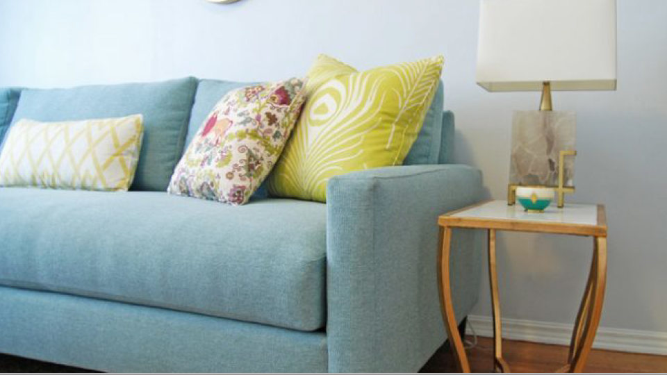 Blue coach with yellow pillows with side table