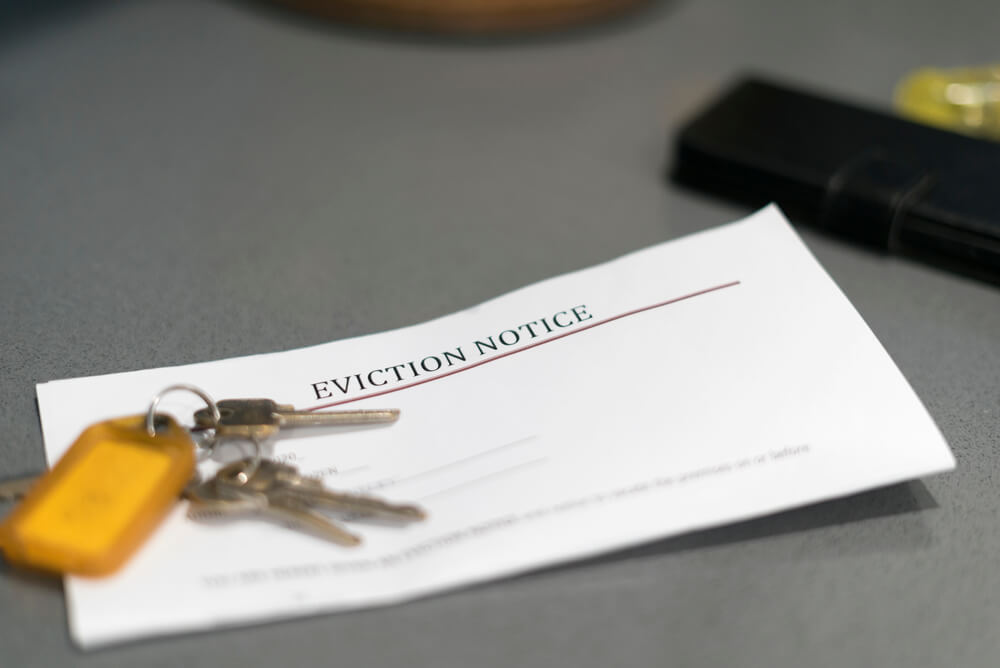 keys on desk with eviction notice letter