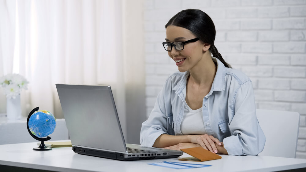woman with glasses reviewing payday loan Florida on laptop