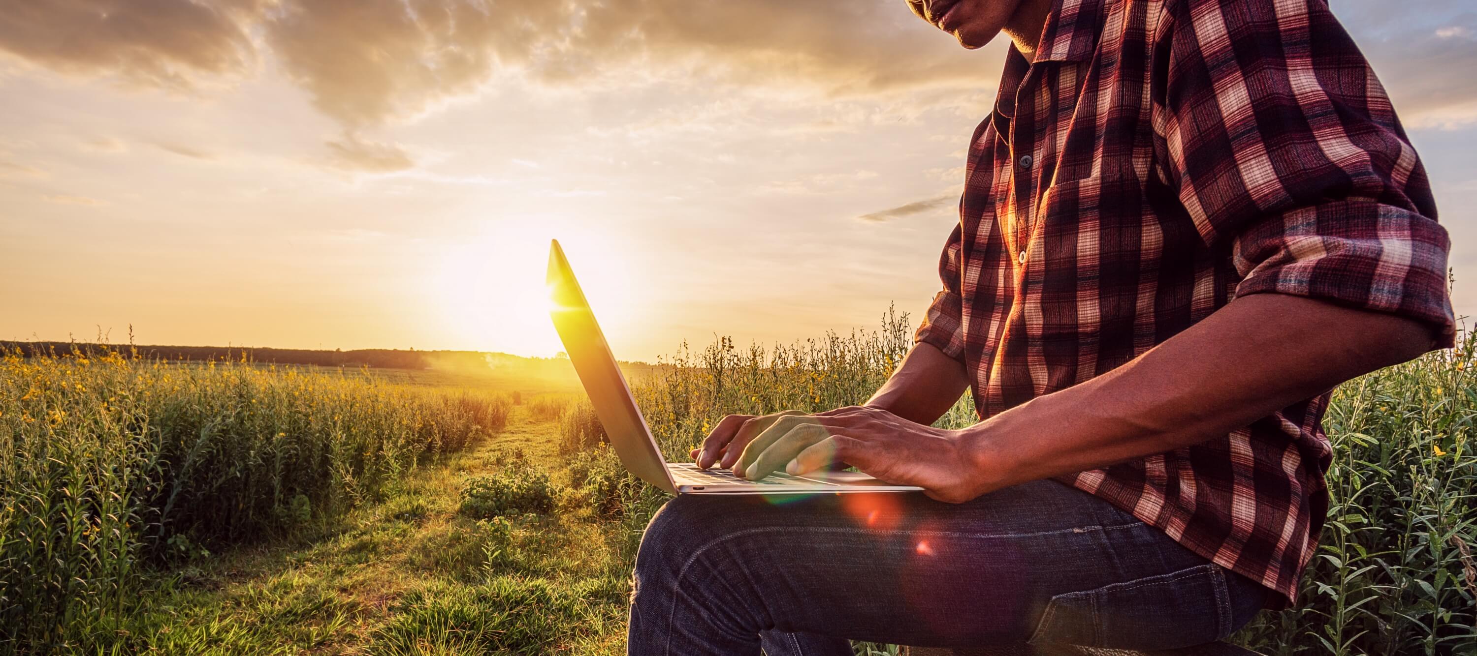 man on laptop in field