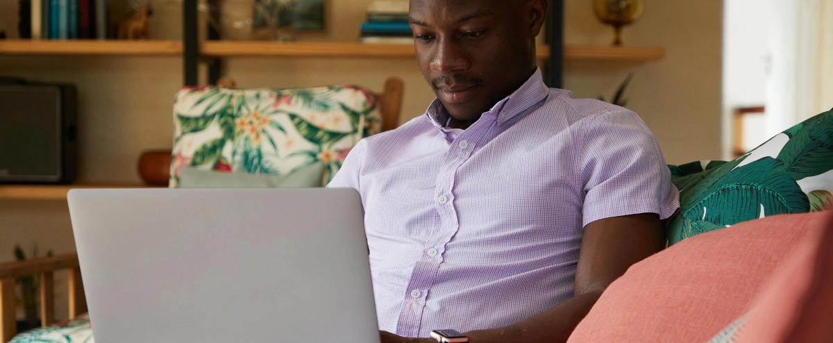 Man using a laptop on his sofa at home