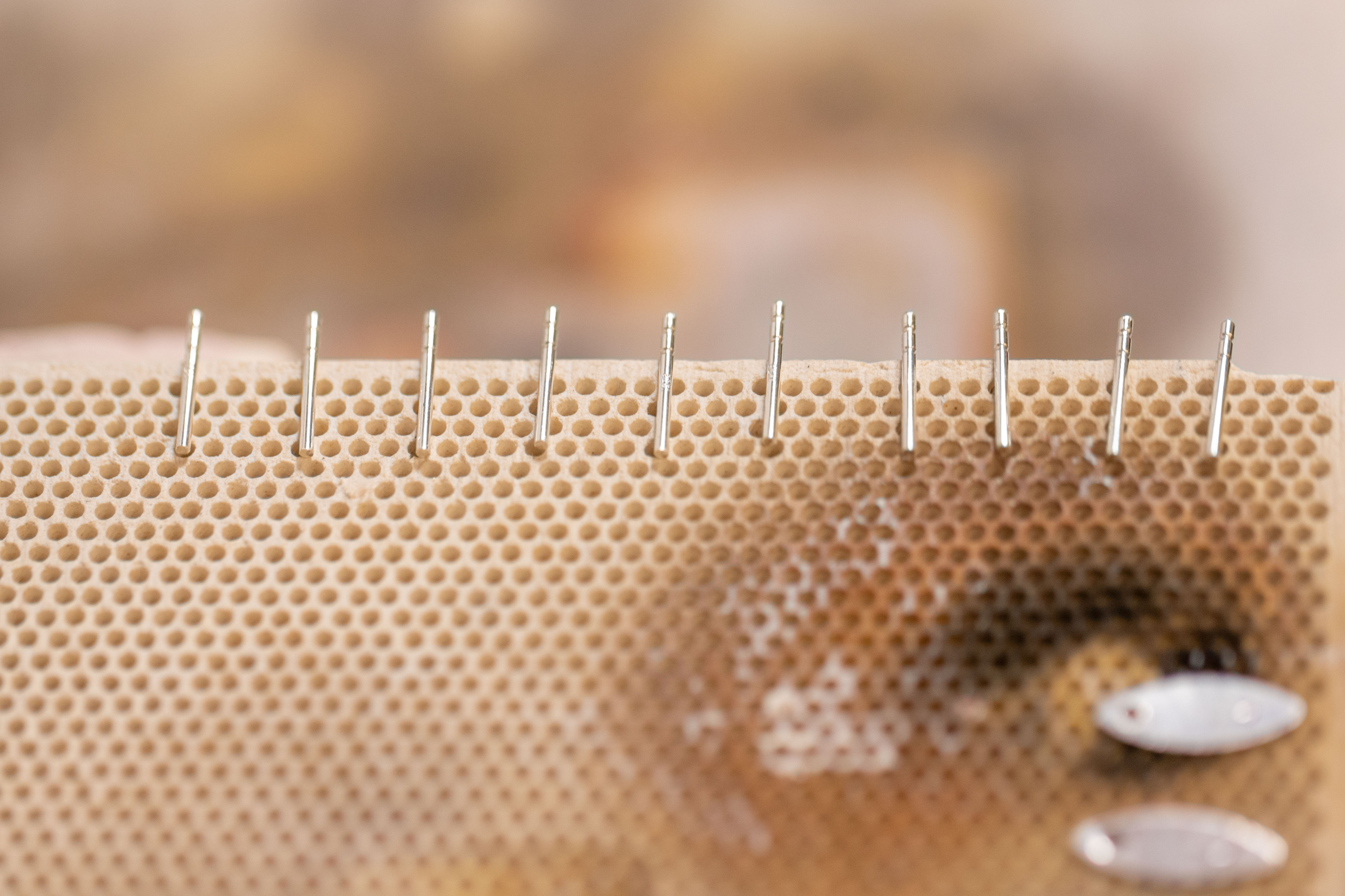 Earring posts lined up on edge of soldering board