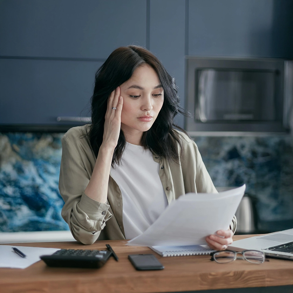 Woman Sitting at Table Thinking.webp
