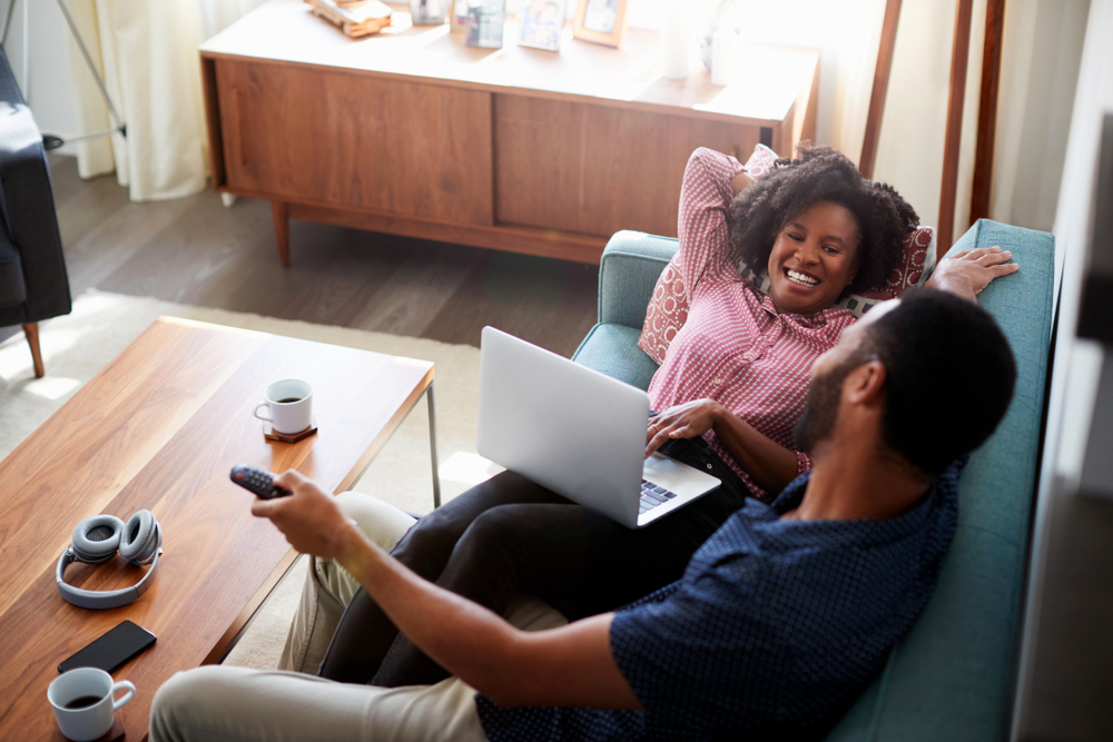 Couple in bright apartment watching TV together