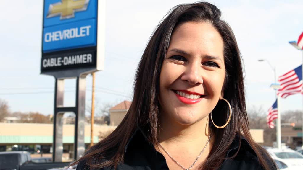 Dealership General Manager with Dealership Sign in Background