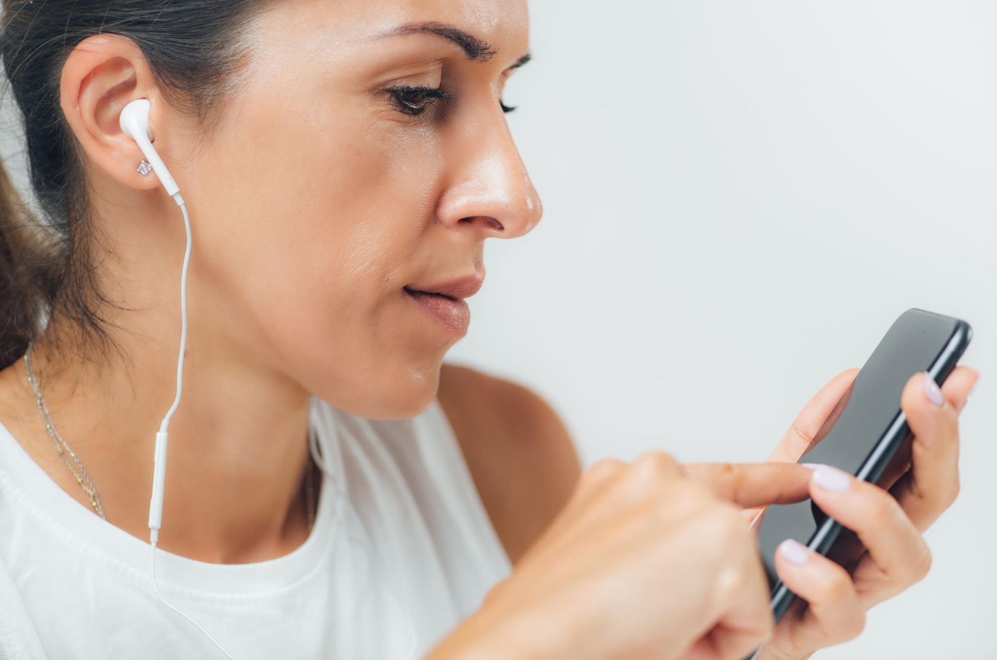 Woman with her earphones on while using her mobile phone