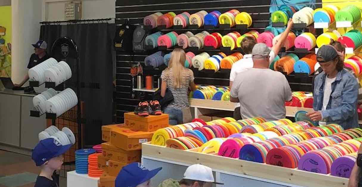 People looking for discs at a large disc golf store