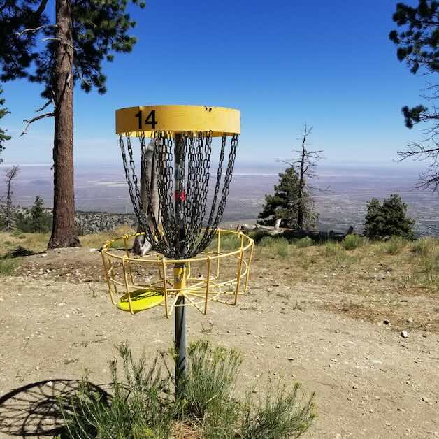 A disc golf basket with an expansive view behind it