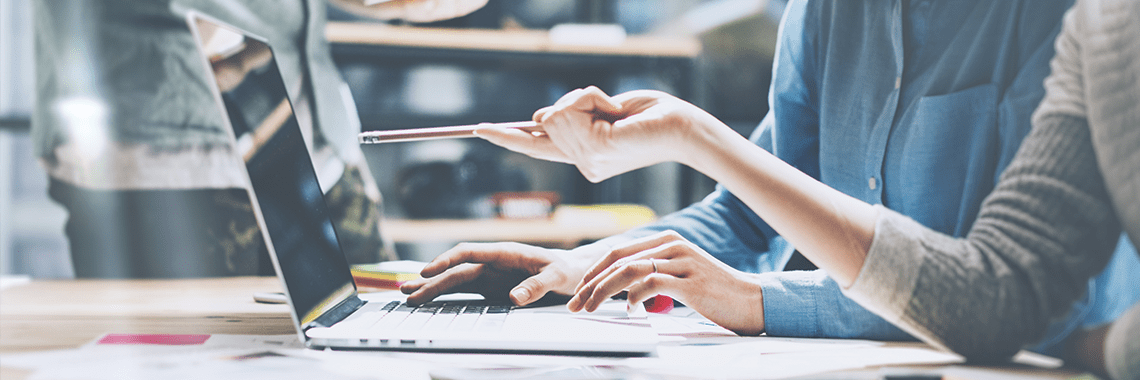 Person pointing a pencil to the computer screen.