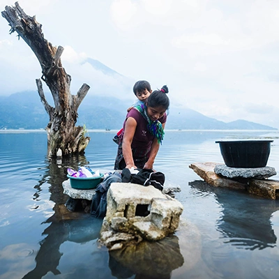 A woman washing clothes in body of water