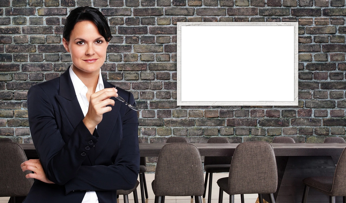 Businesswoman in a dark suit discussing sales strategies in a conference room.