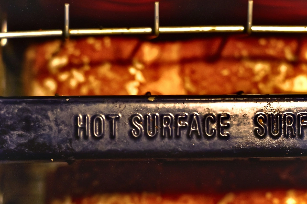 Picture of heating source with metal that says, "hot surface".