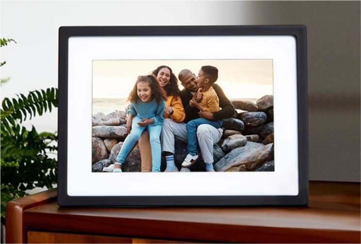 Family having fun near the ocean, displayed on digital photo frame