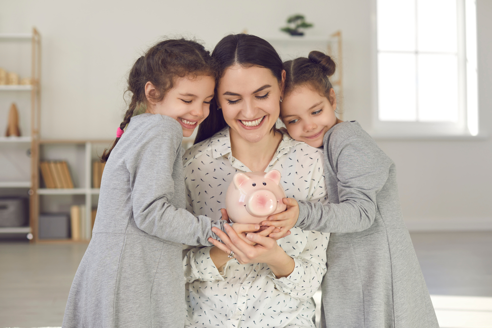 Mum holding money box with her two children.
