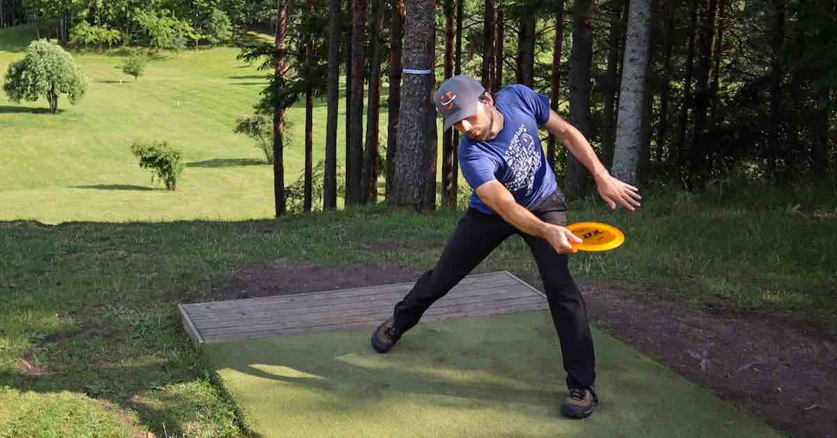 Player about to throw a backhand from a disc golf tee