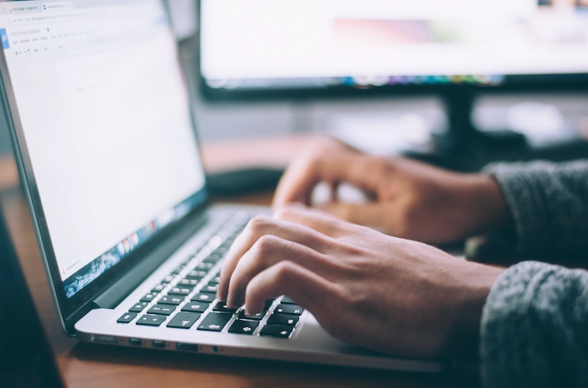 Hands showing typing on a laptop