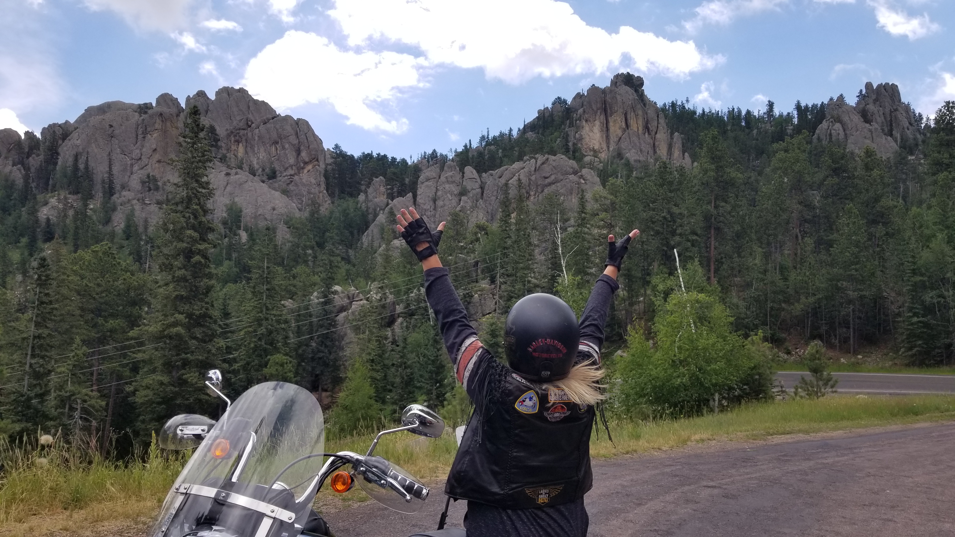 Cindy Bike Hands up Mountains.jpg