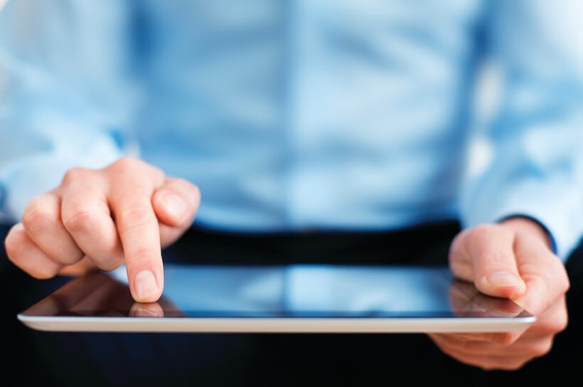 Person wearing a blue shirt holding an ipad device 