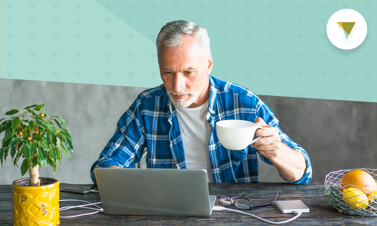 Elderly man doing research on laptop.