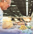 homem pegando frutas no mercado, dieta com vitaminas como idosos
