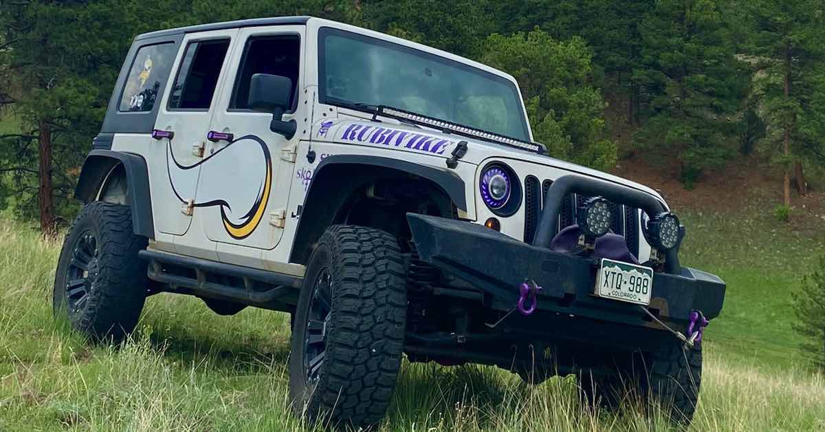 A white Jeep Rubicon with Minnesota Vikings team symbols and colors